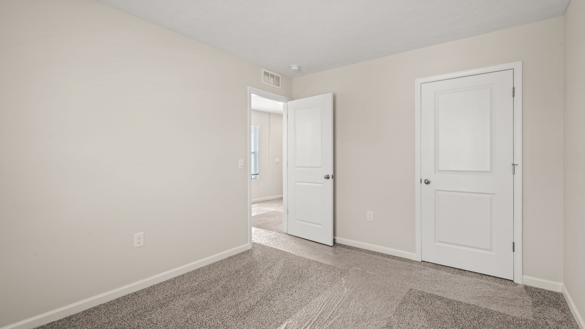 Carpeted bedroom with door to hallway
