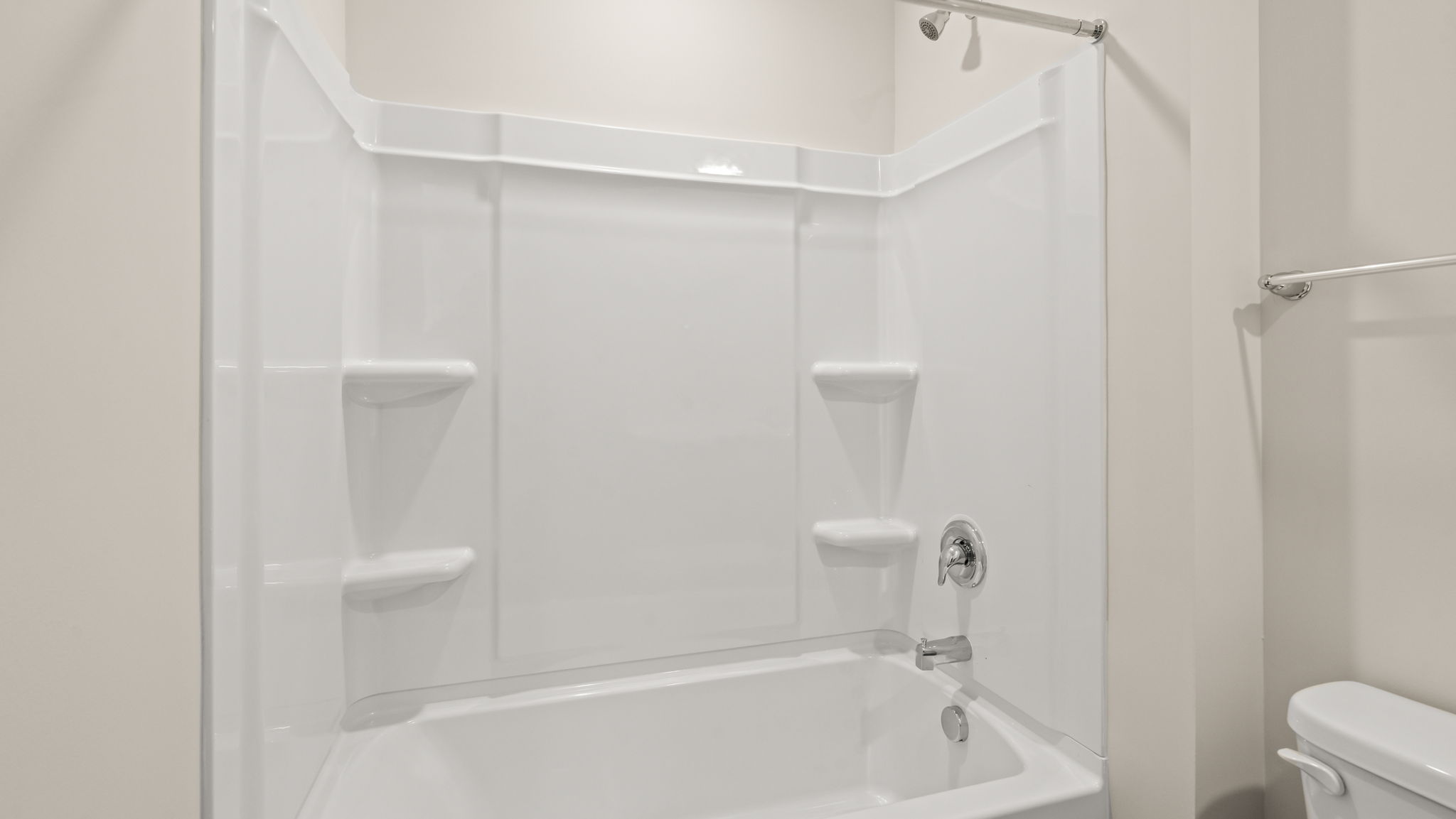 Closeup of tub with shower and tiered shelving
