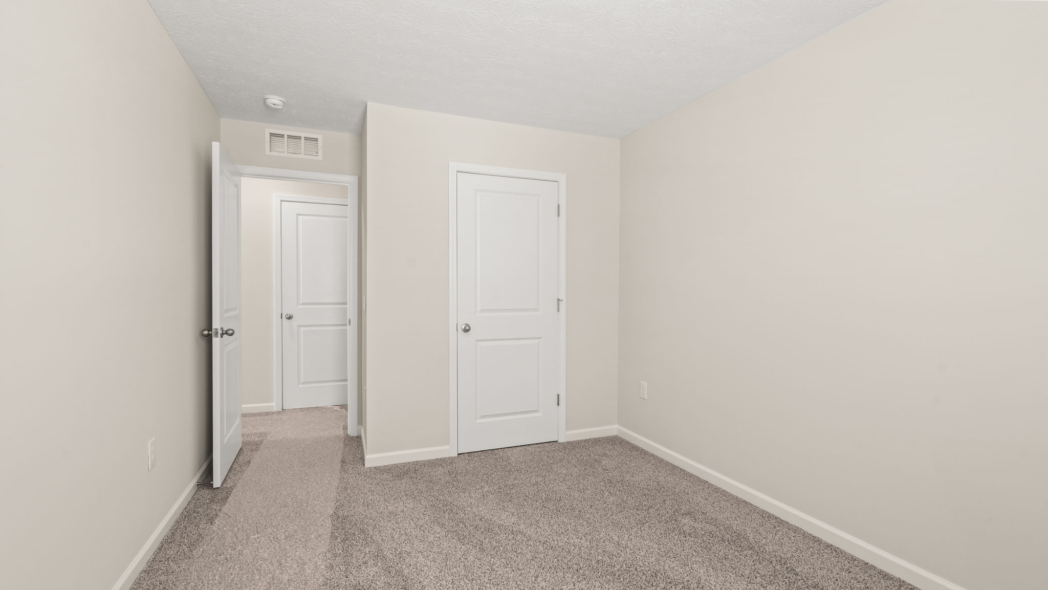 Carpeted bedroom with closet door