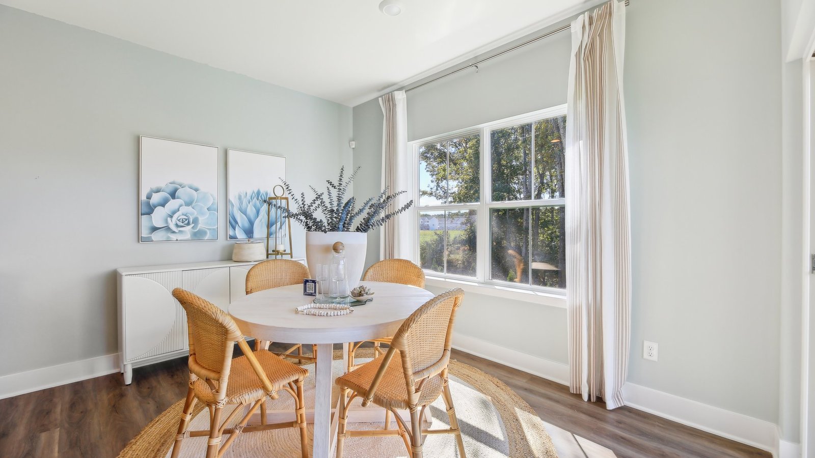 dining area with wooden chairs and lots of window light.
