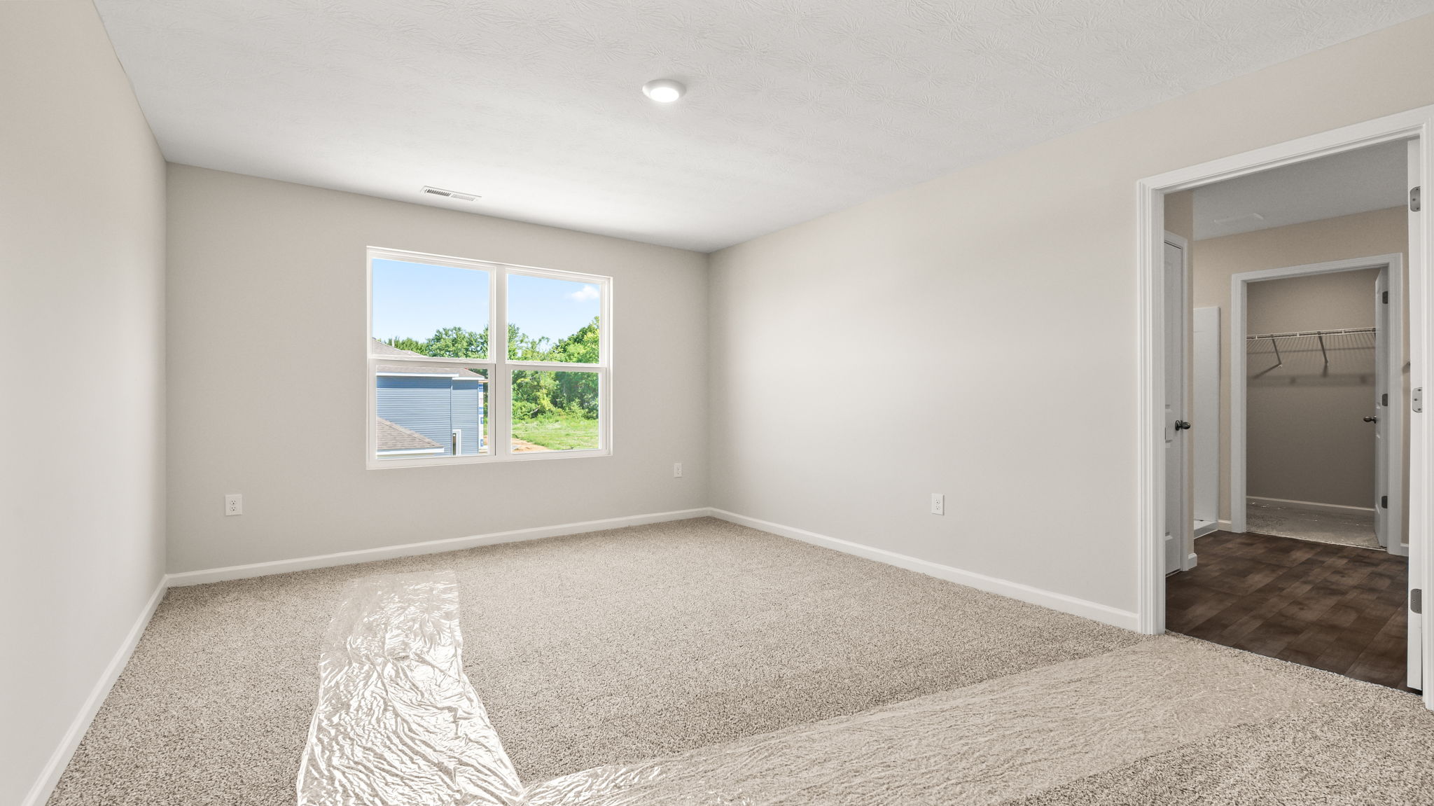 Carpeted primary bedroom with window