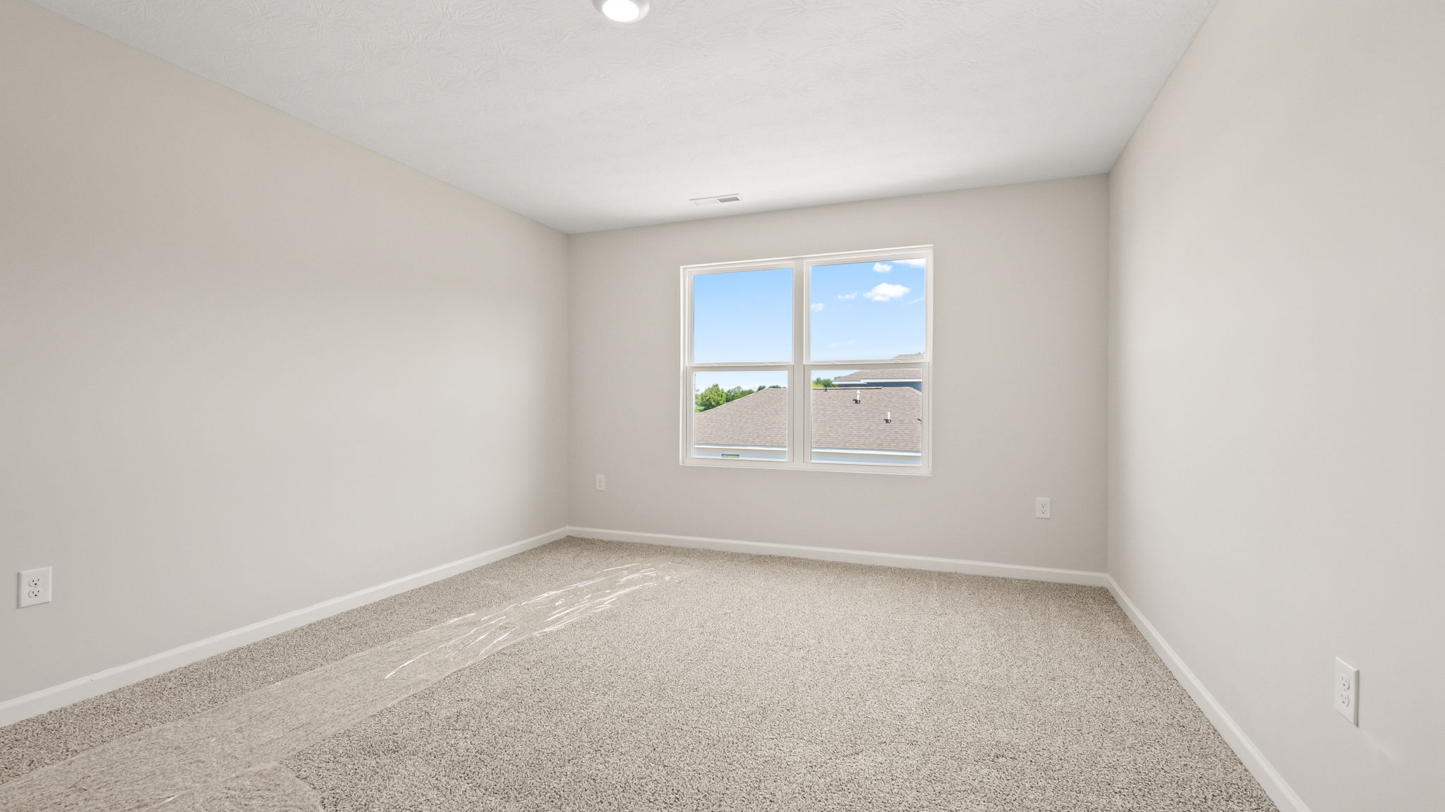 Carpeted primary bedroom with window