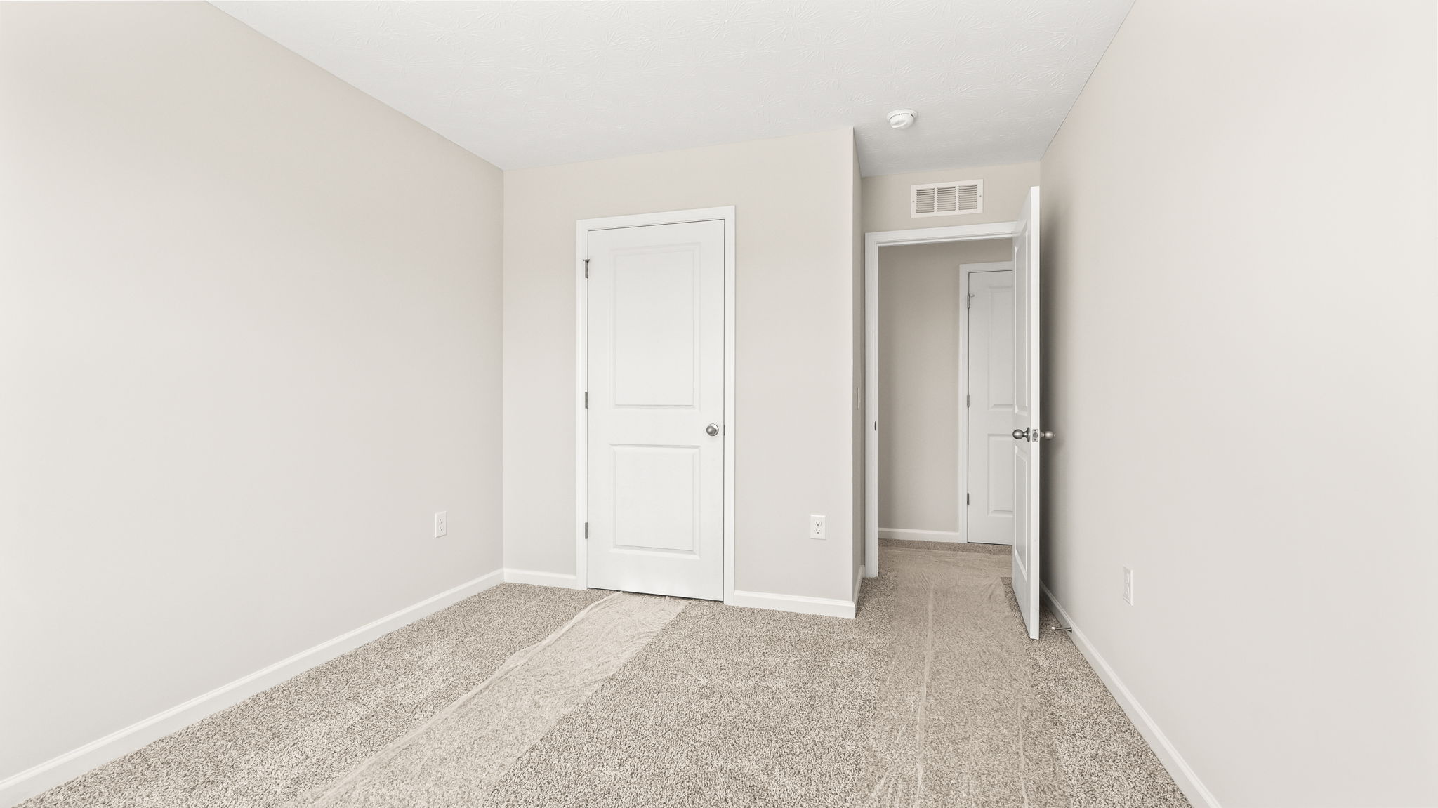Carpeted bedroom with door to closet