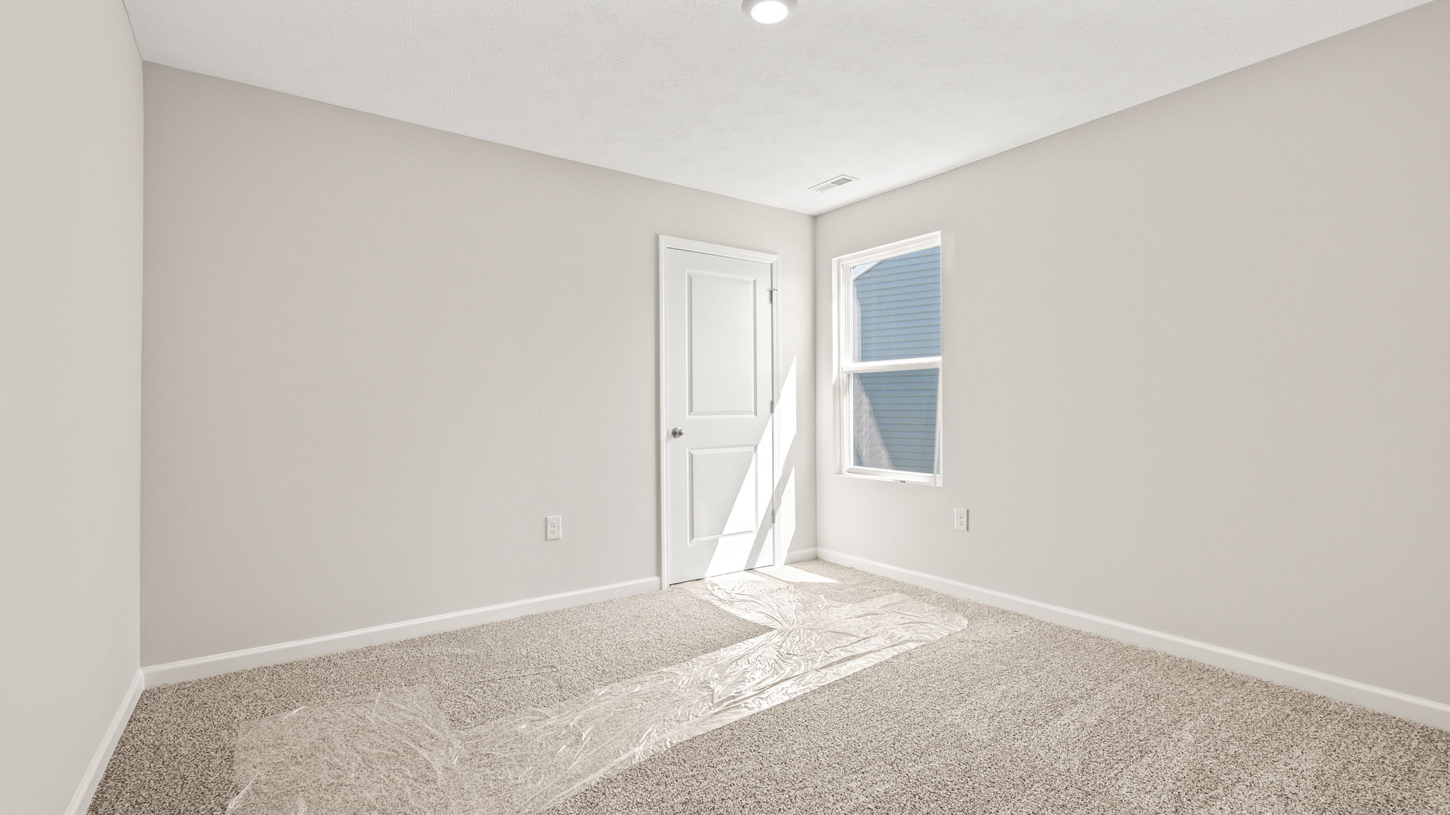 Carpeted bedroom with window