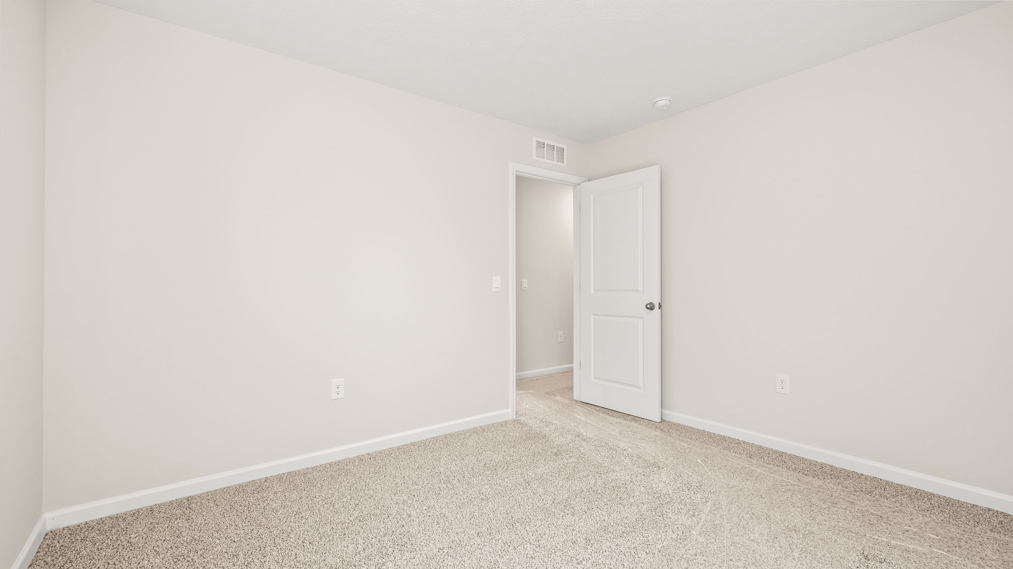 Carpeted bedroom with door to hallway