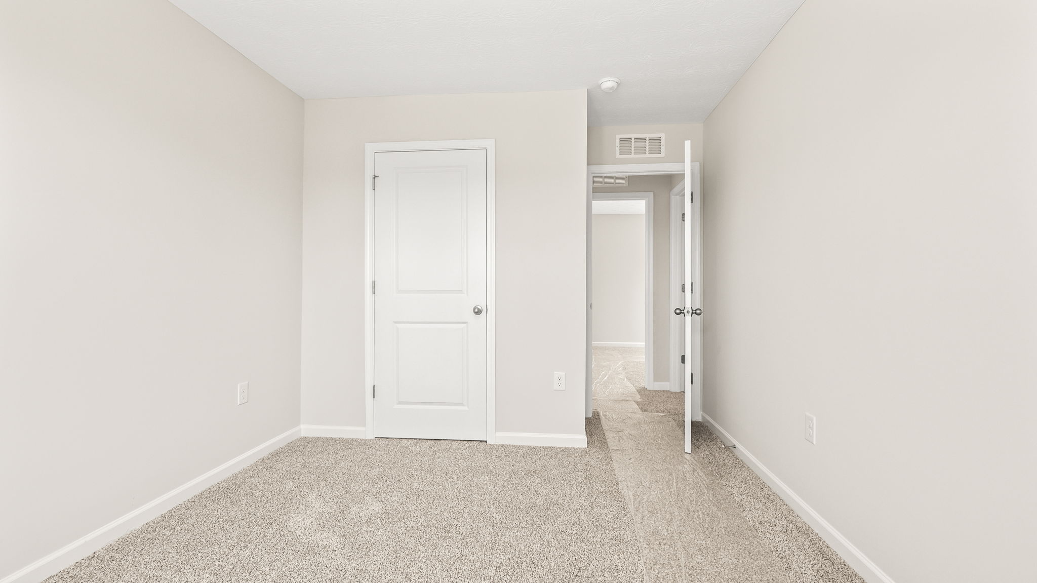 Carpeted bedroom with door to closet