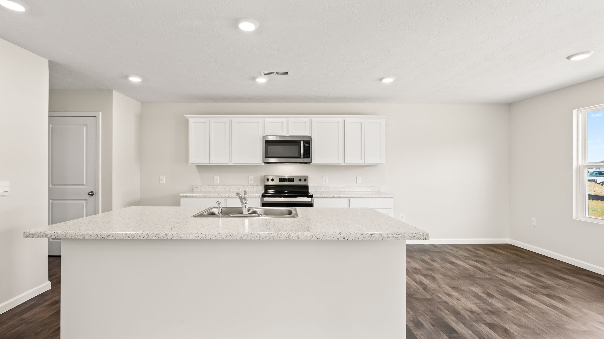 Front view of kitchen with white cabinetry and island