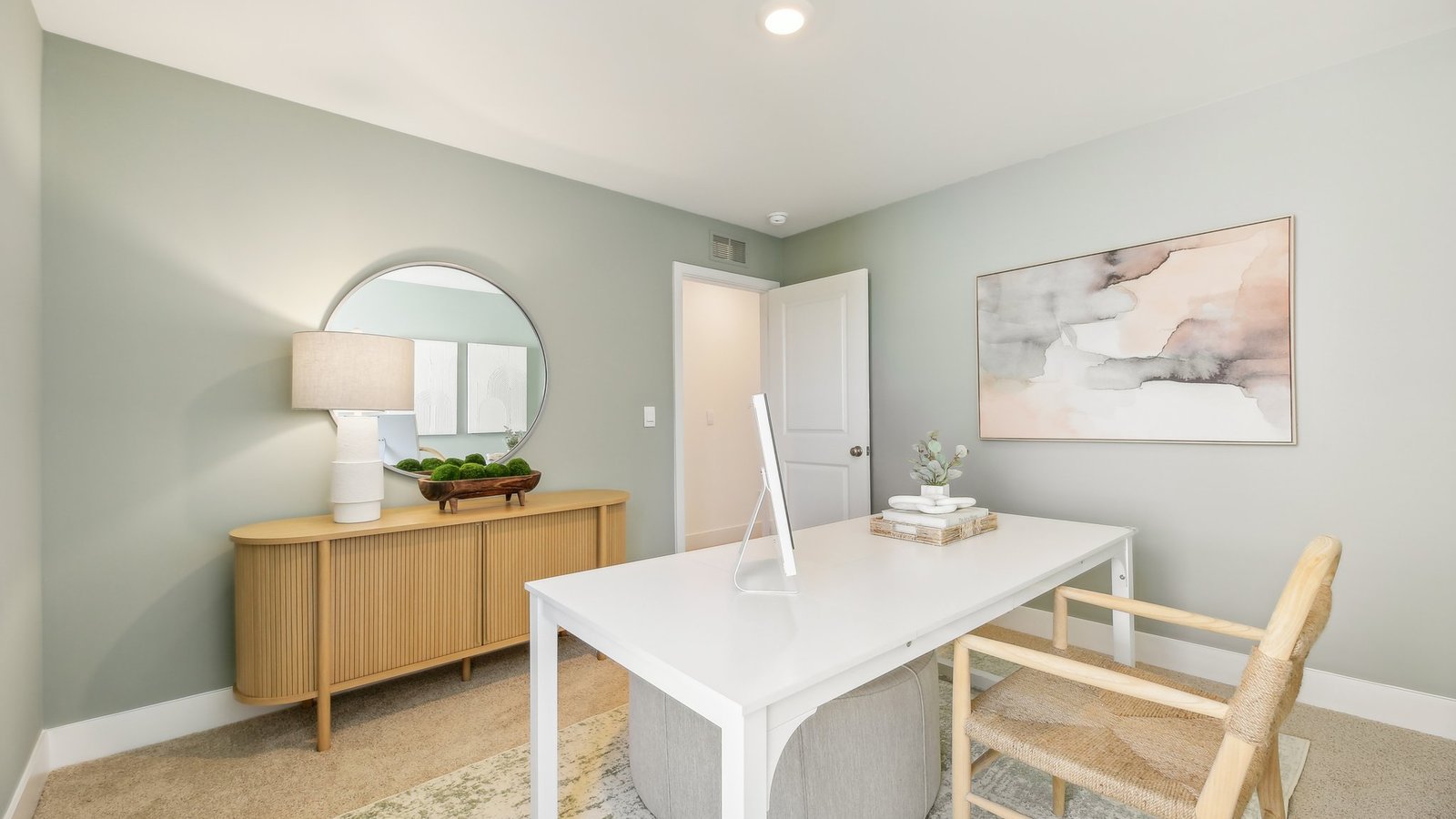 Bedroom staged as an office with white desk.