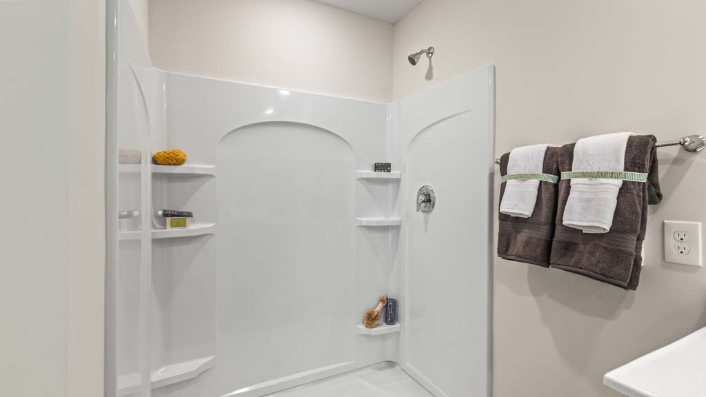Private bathroom shower with ample shelf space.