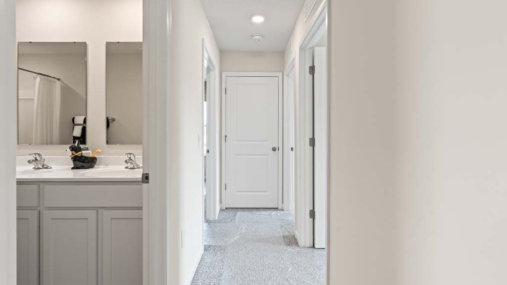 Upstairs hallway peaking into the shared bathroom space.