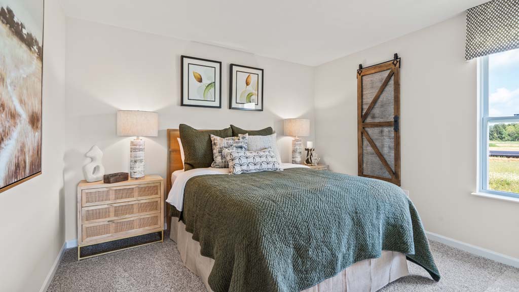 Bedroom with large dark green bed with wooden accents.