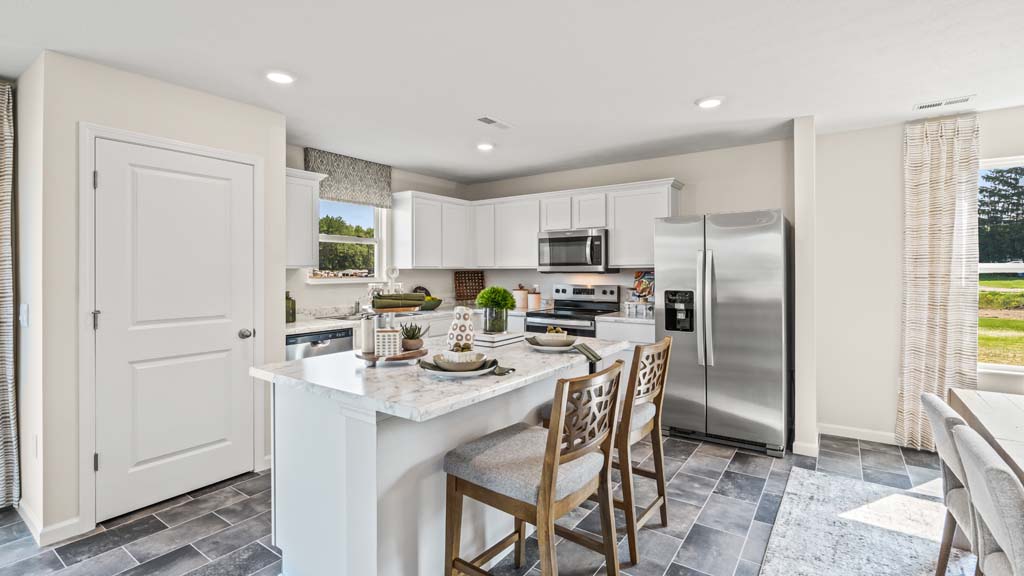 Kitchen with whirlpool appliances, large island, and white cabintry.