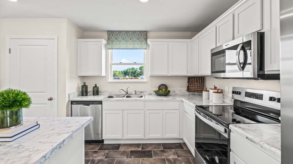 Kitchen with whirlpool appliances, large island, and white cabintry.