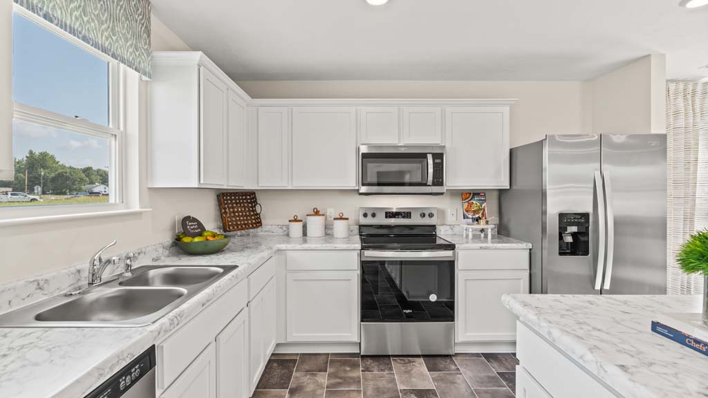 Kitchen with whirlpool appliances, large island, and white cabintry.
