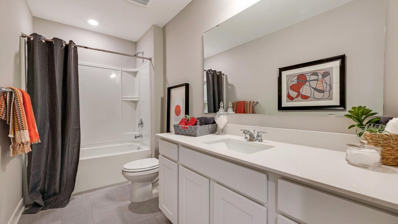 shared bathroom with colorful accents and white countertops.