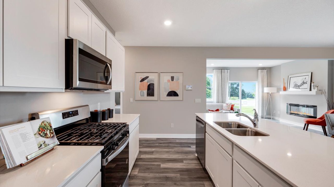 shotgun view of the kitchen with white cabinets and countertops.