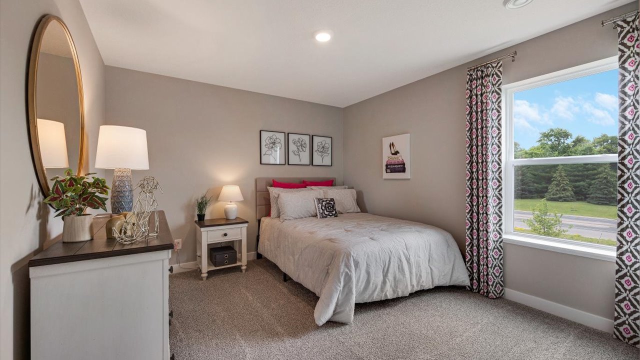 bedroom with wooden white decorations and large corner bed.