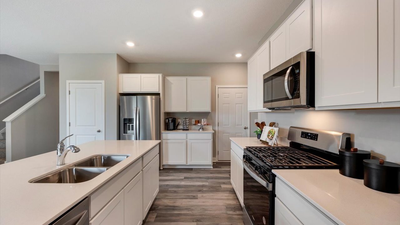 shotgun view of the kitchen with white cabinets and countertops.