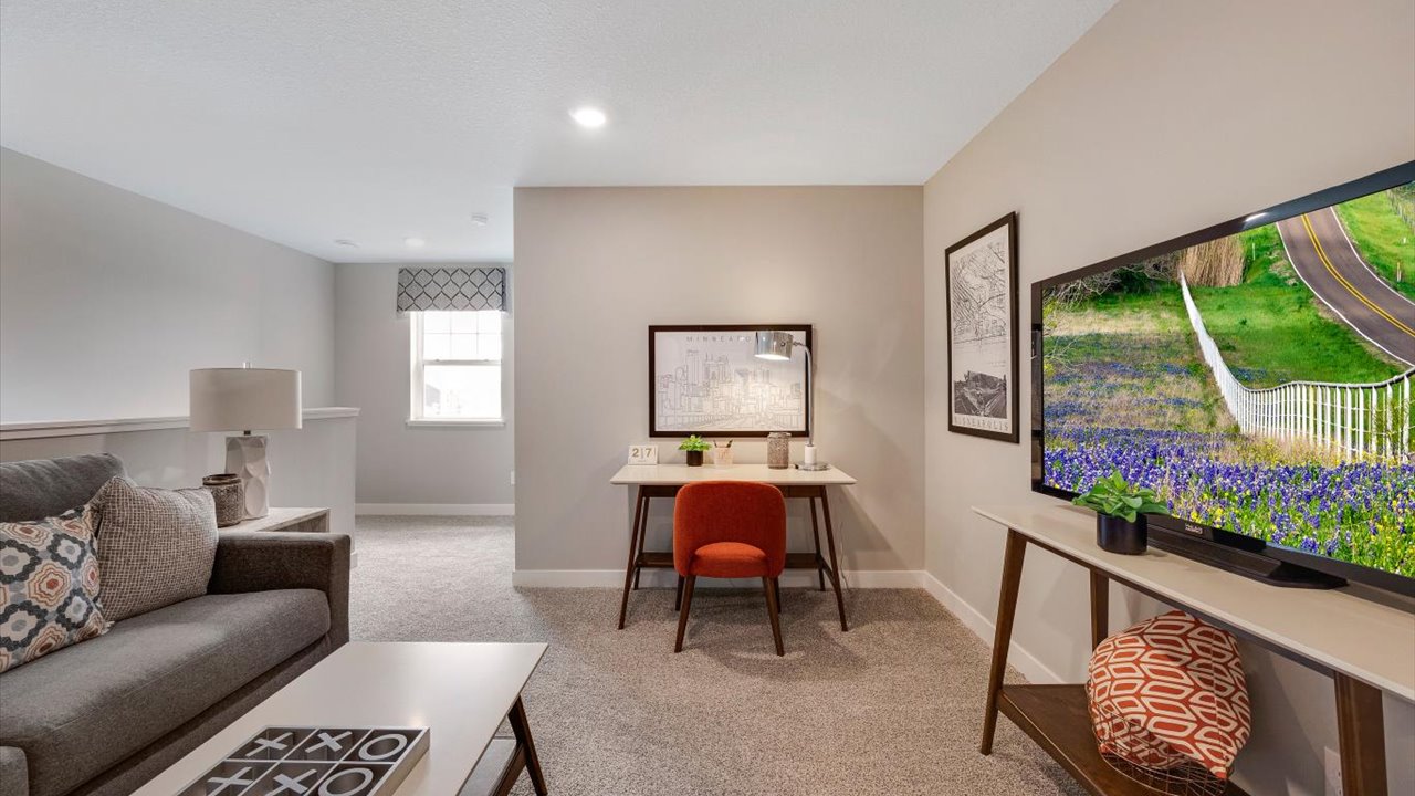 Loft on the second floor with comfy couch, coffee table, and desk area.