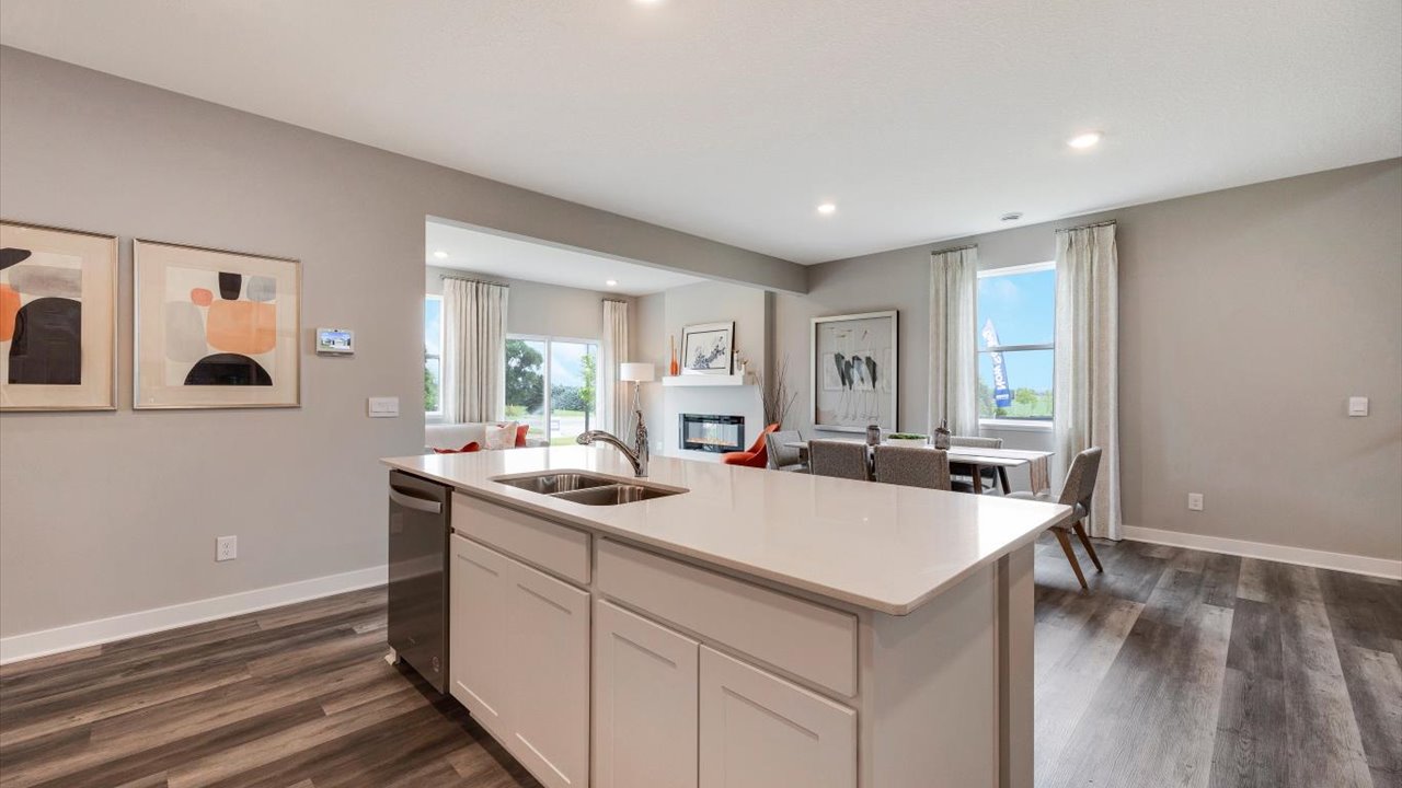 Kitchen island looking out into great room with dining room and decorative art.