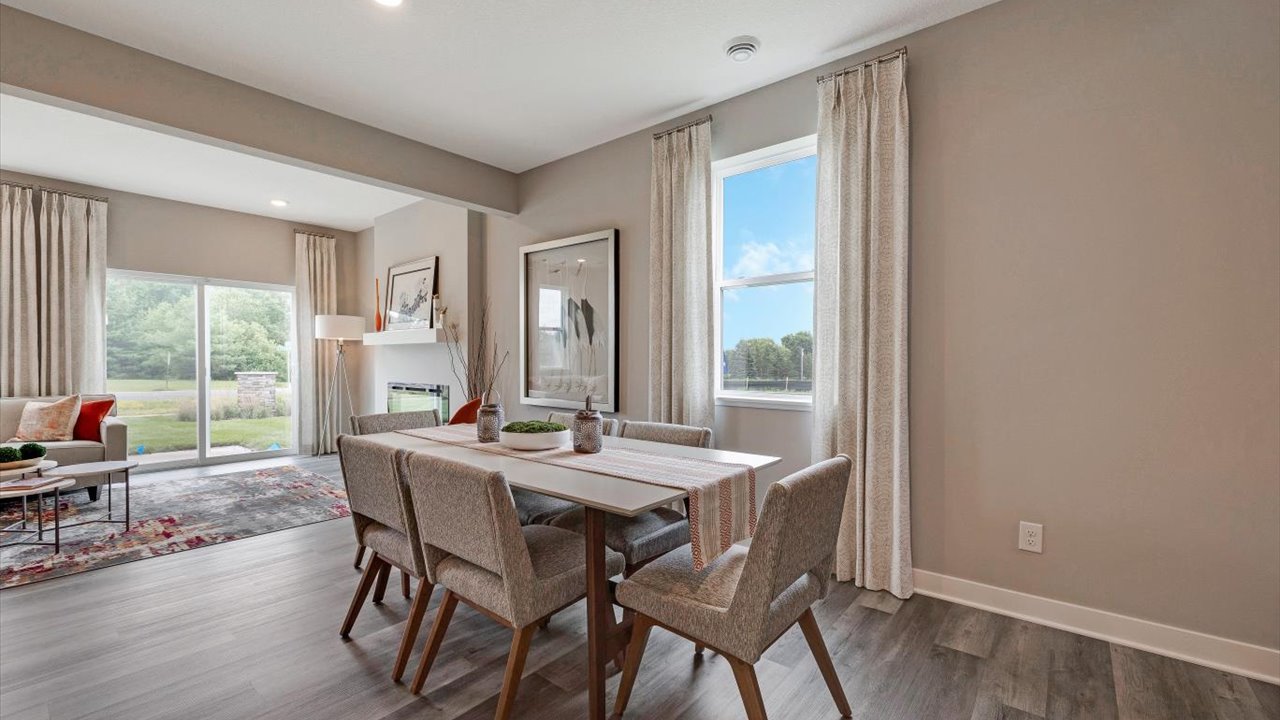 Dining room with plush chairs and wooden  table and modern art.