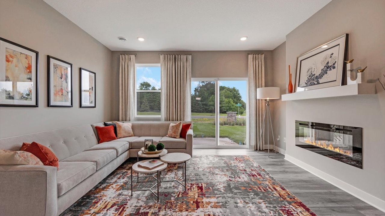 Living room with colorful accents and a electric fireplace.