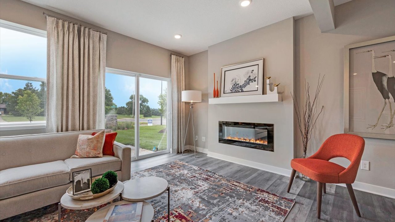 Living room with colorful accents and a electric fireplace with full sliding door to backyard.