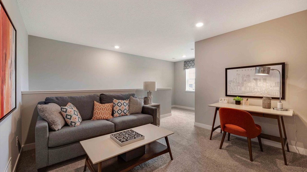 Loft on the second floor with comfy couch, coffee table, and desk area.