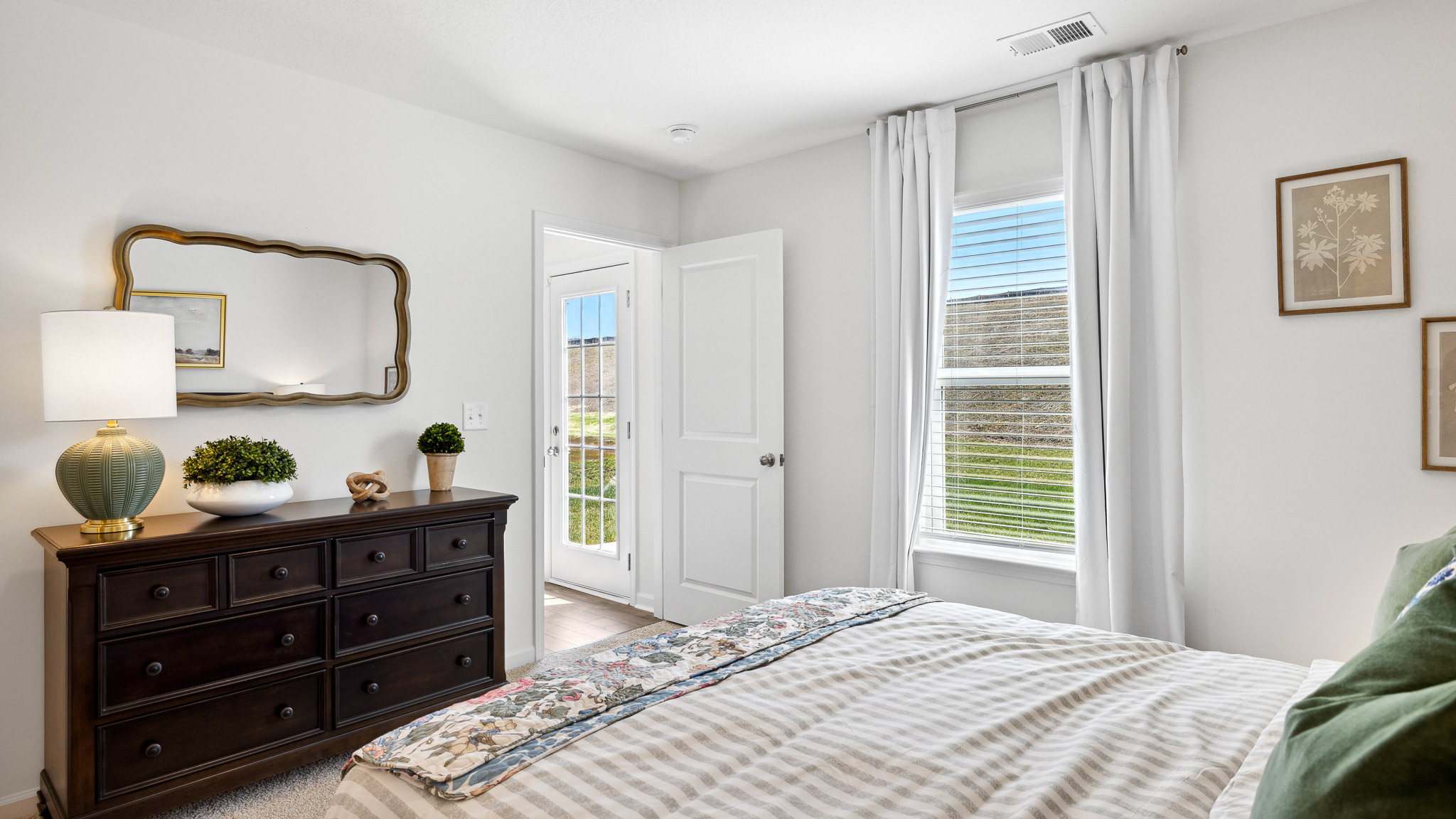 primry bedroom with dresser and door