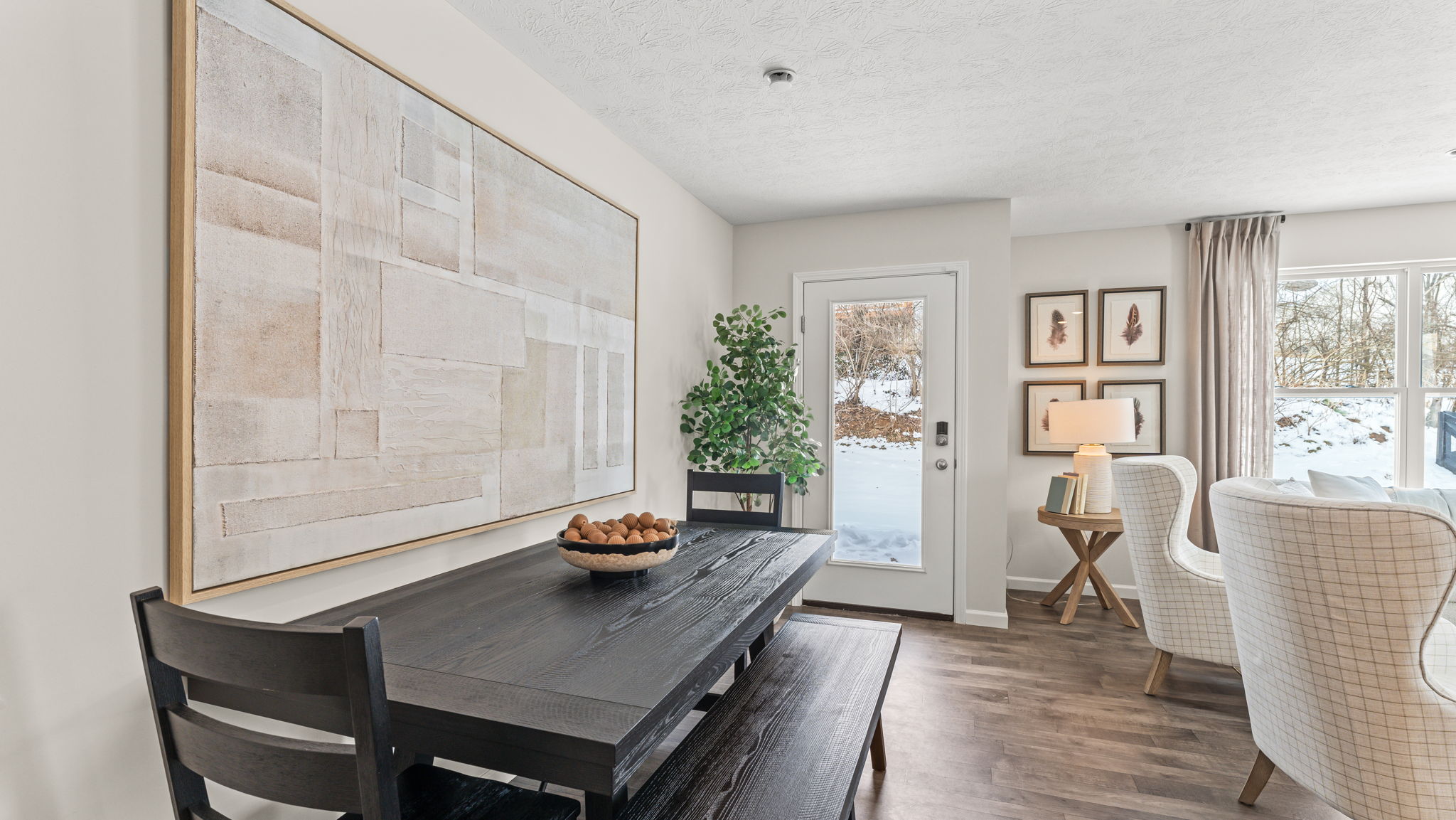 Closeup of dark brown wood kitchen table next in front of the backdoor.