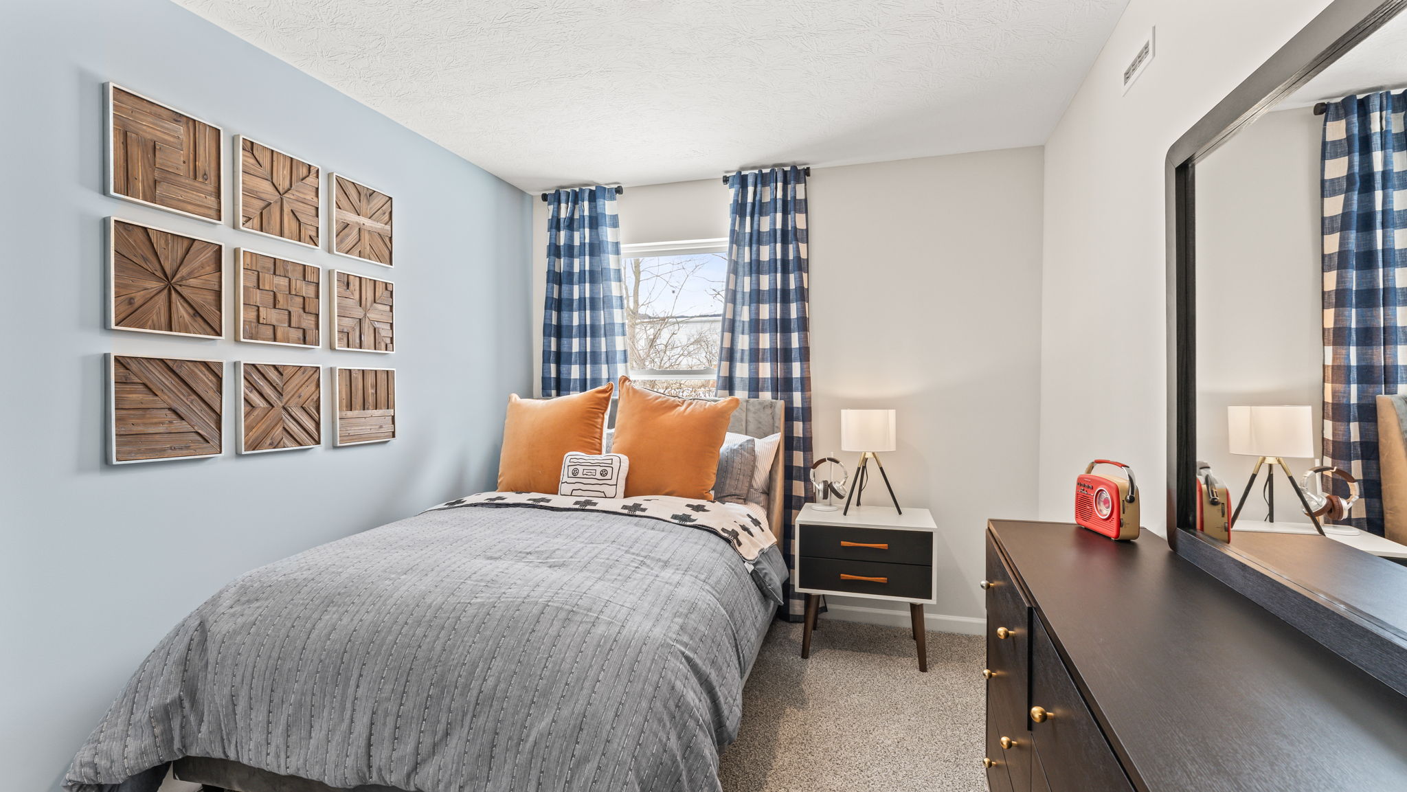 Blue and brown toned bedroom with wall art pieces arranged in a grid of various braid patterns
