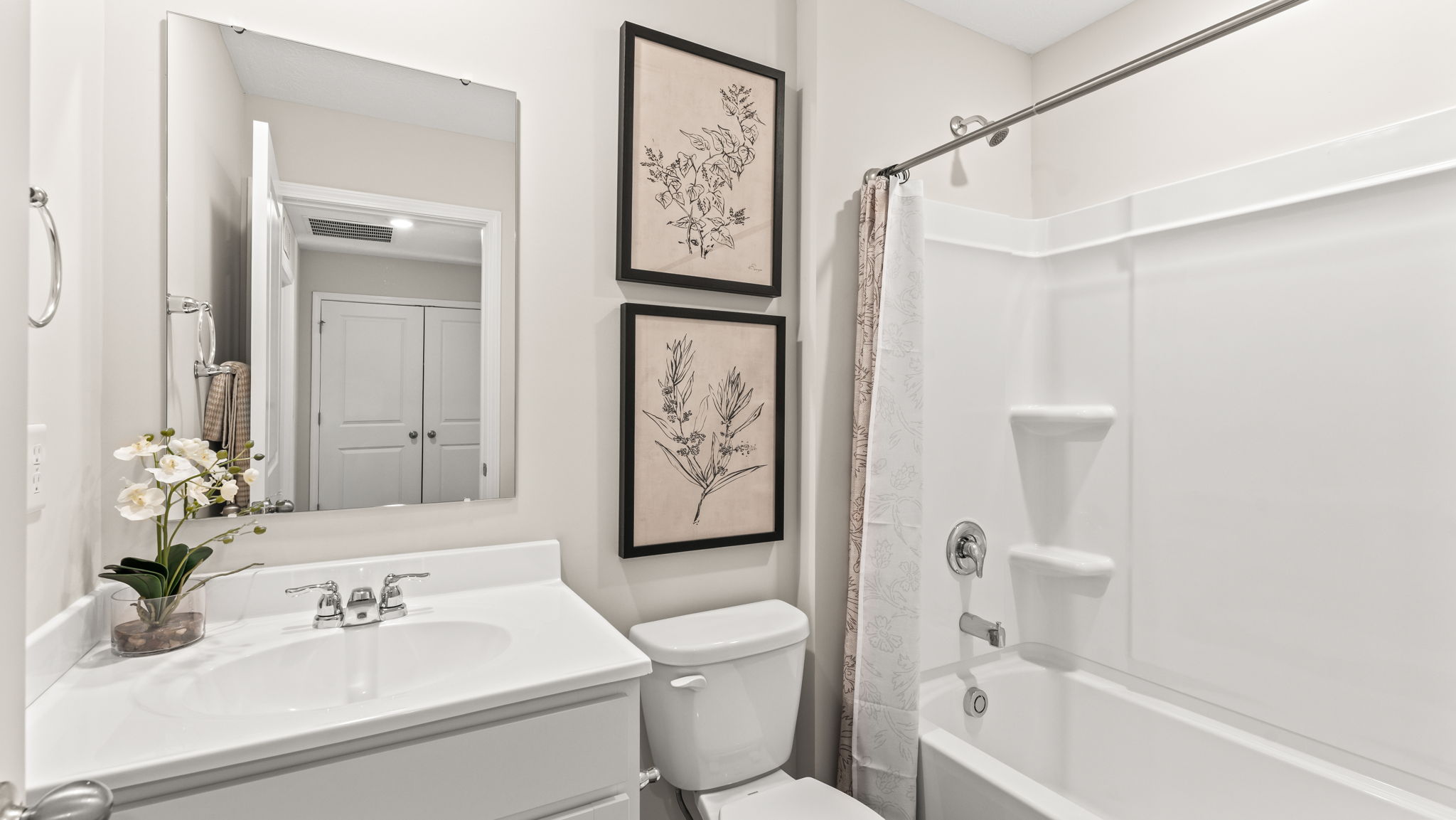 Upstairs bathroom with tub/shower combo, white sink countertop, toilet, and mirror