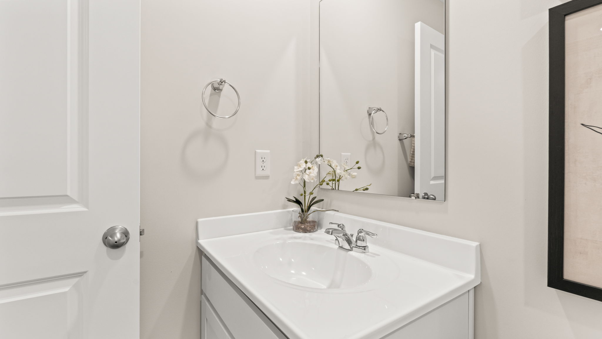 White counterop on sink with hand-towel ring and mirror