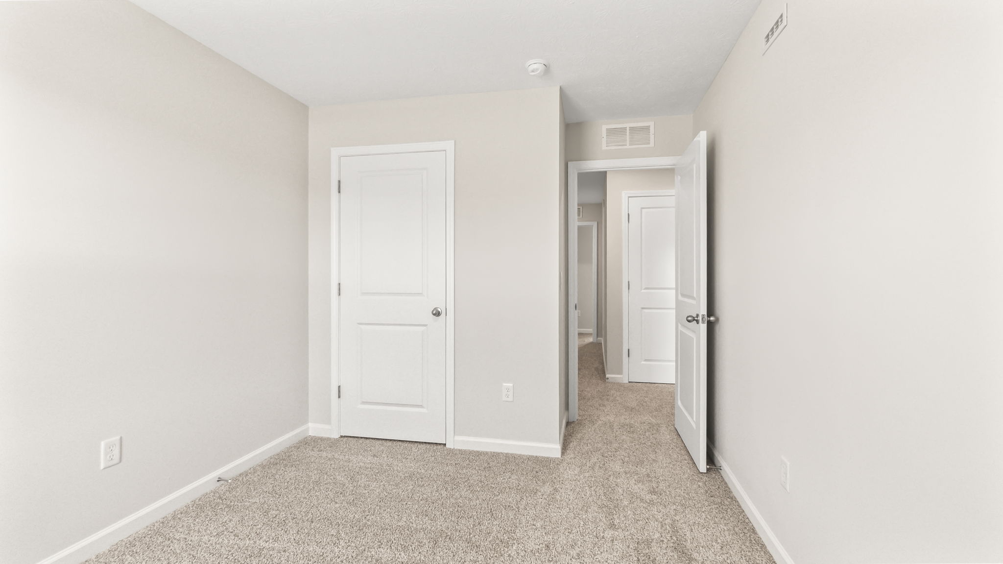 Carpeted bedroom with door to hallway