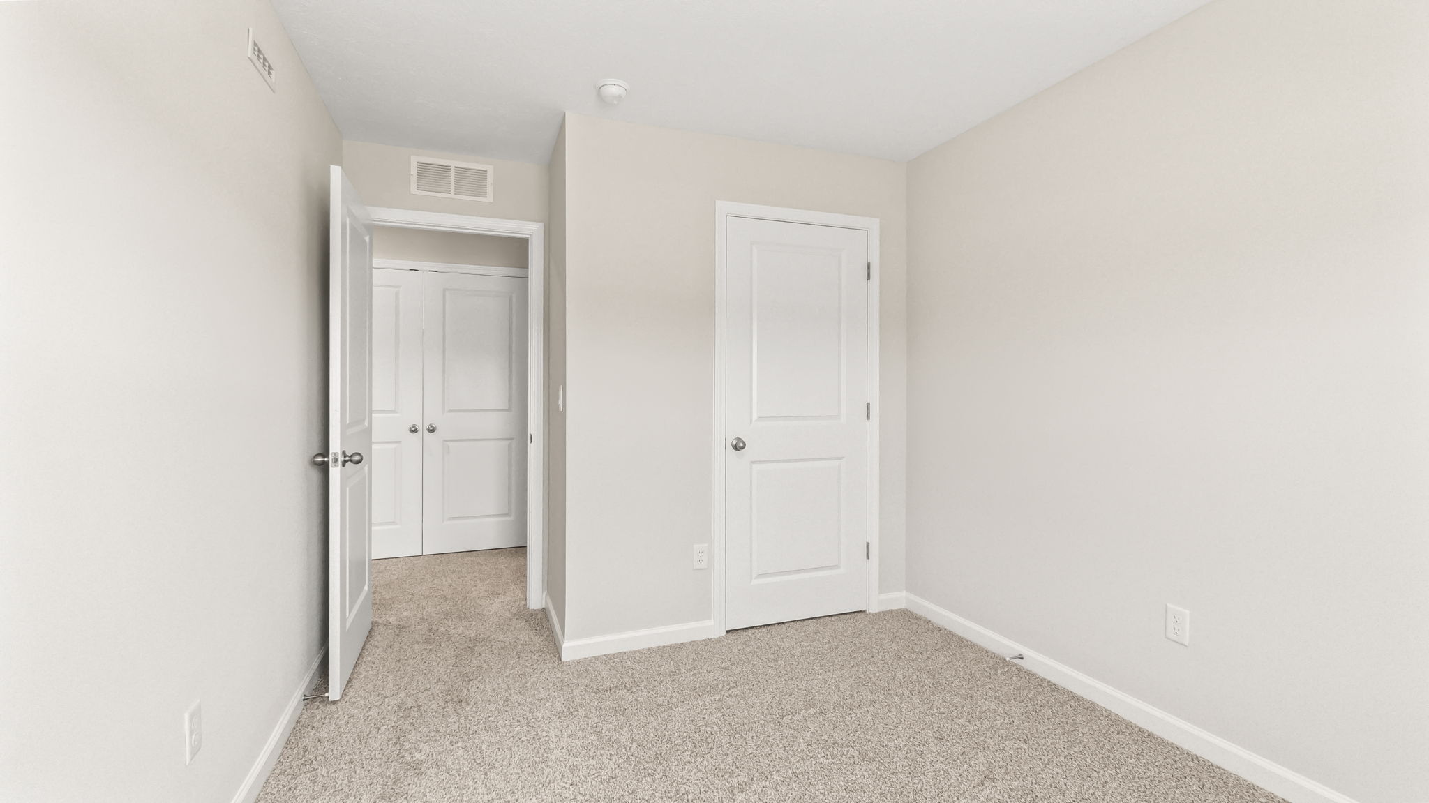Carpeted bedroom with door to hallway