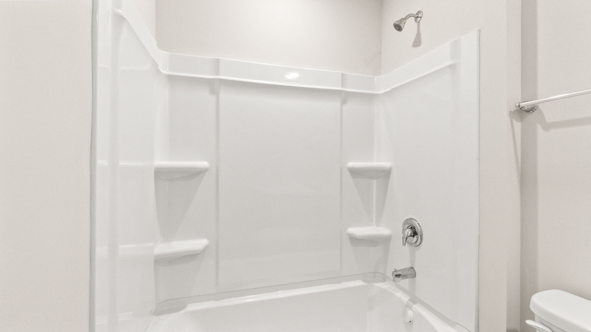 closeup of tub/shower combo with tiered shelving