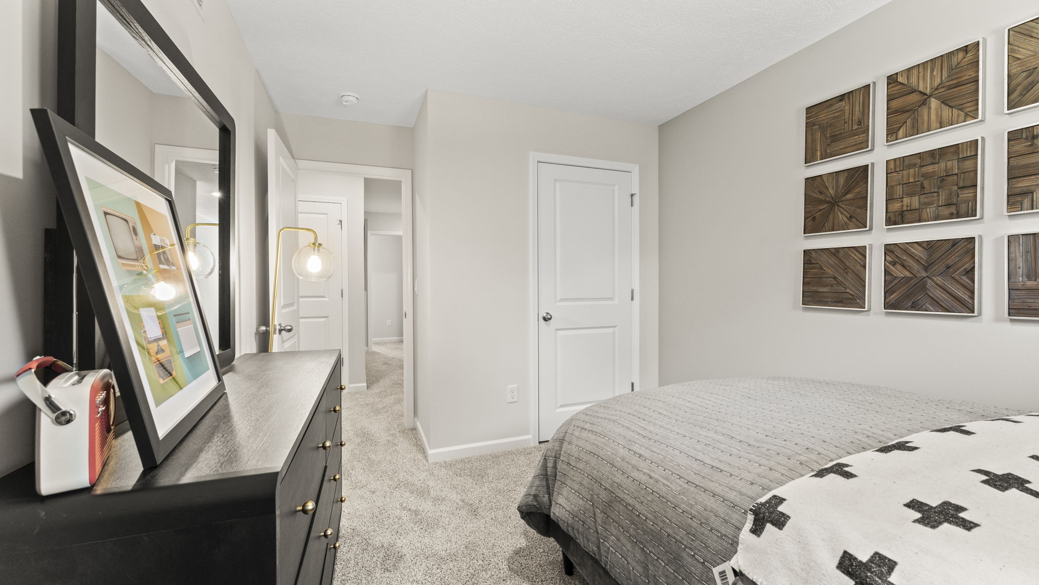 Bedroom with drawer, bed, and closet in view.