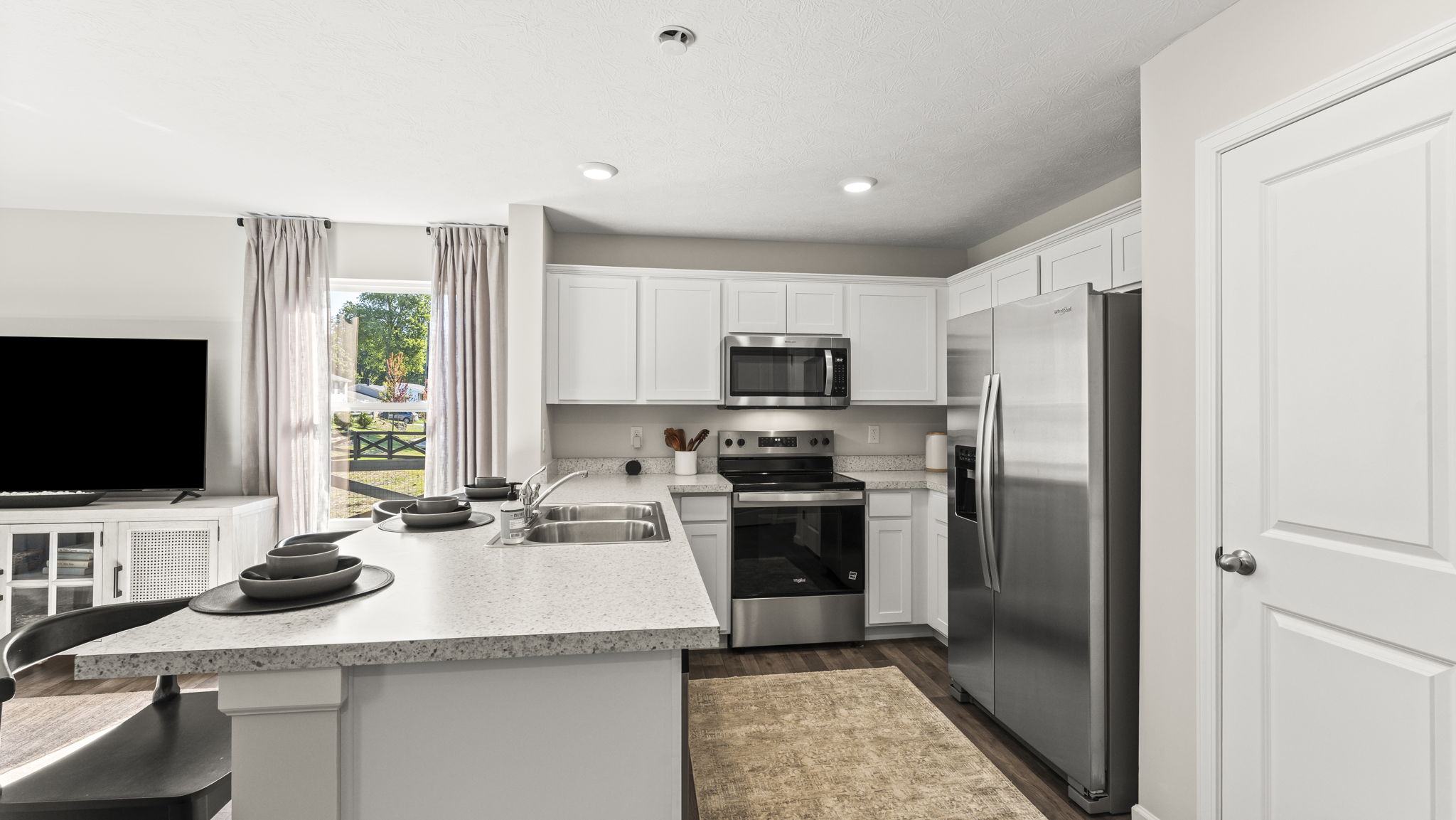 Full view of the kitchen with white cabinets and stainless steel appliances.