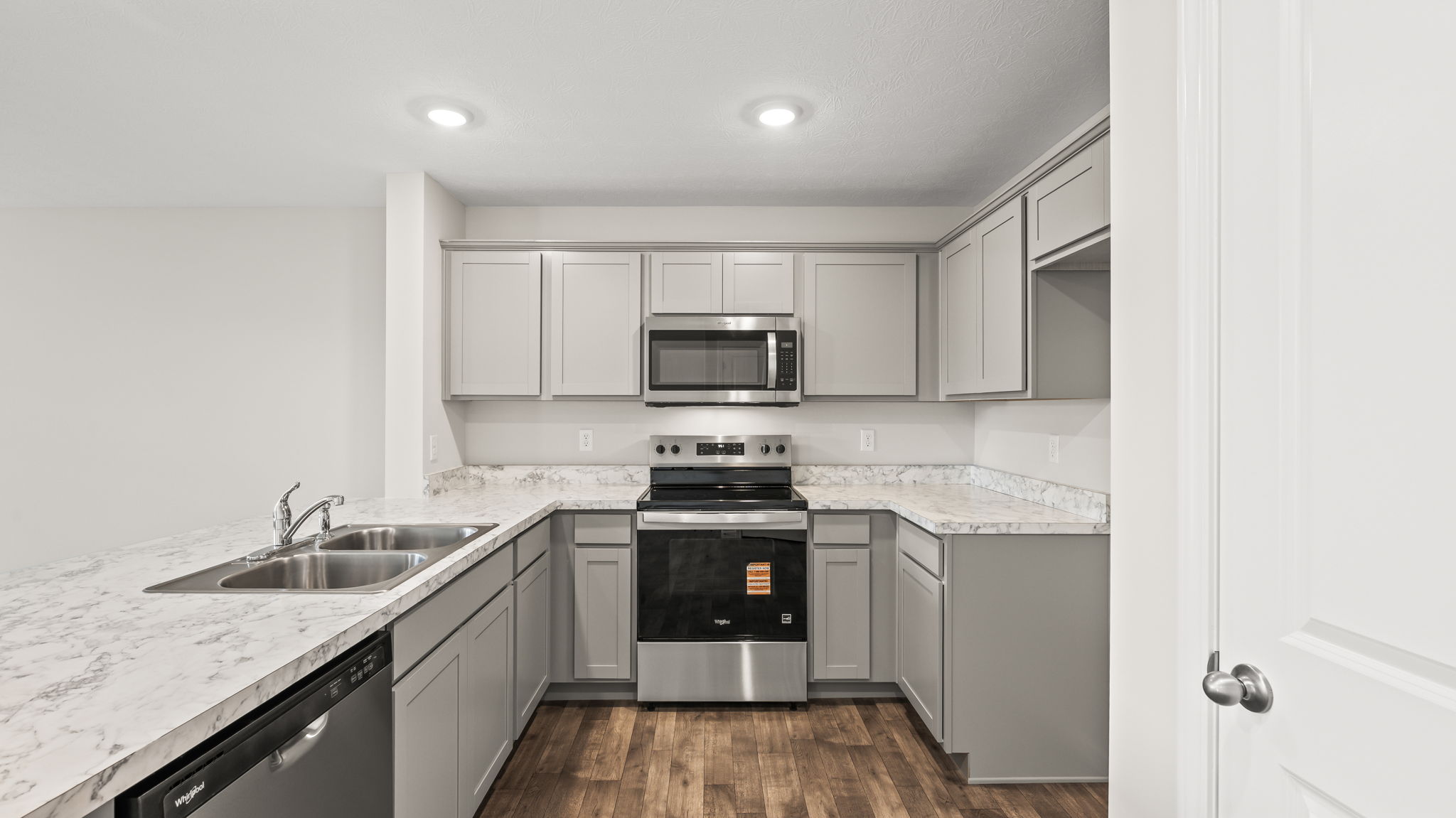 full kitchen from side view with appliances including dishwasher, oven, and microwave.