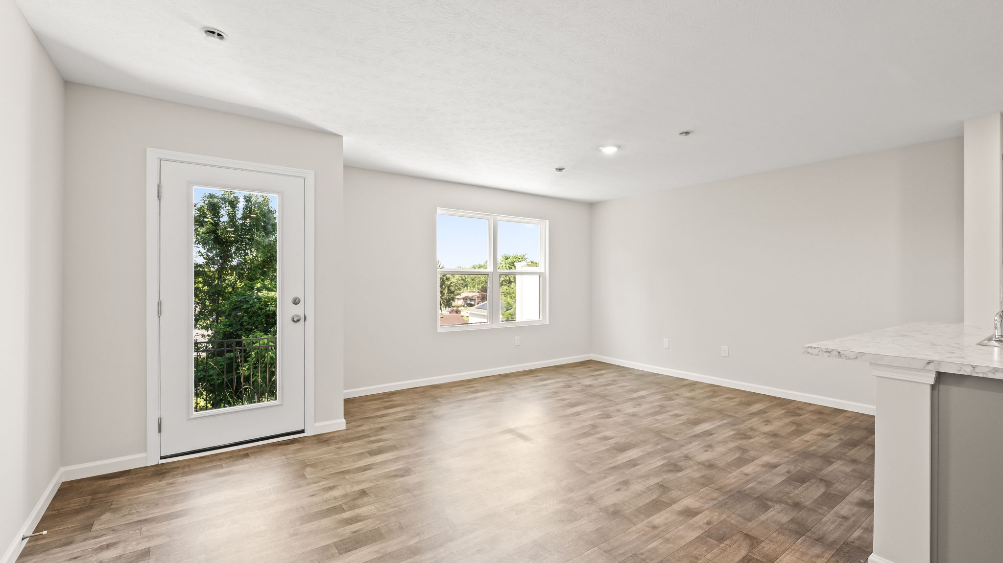 Wide image of living room with door to backyard