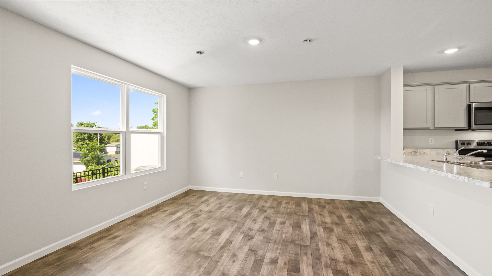 Wide image of living room with window to backyard on the right