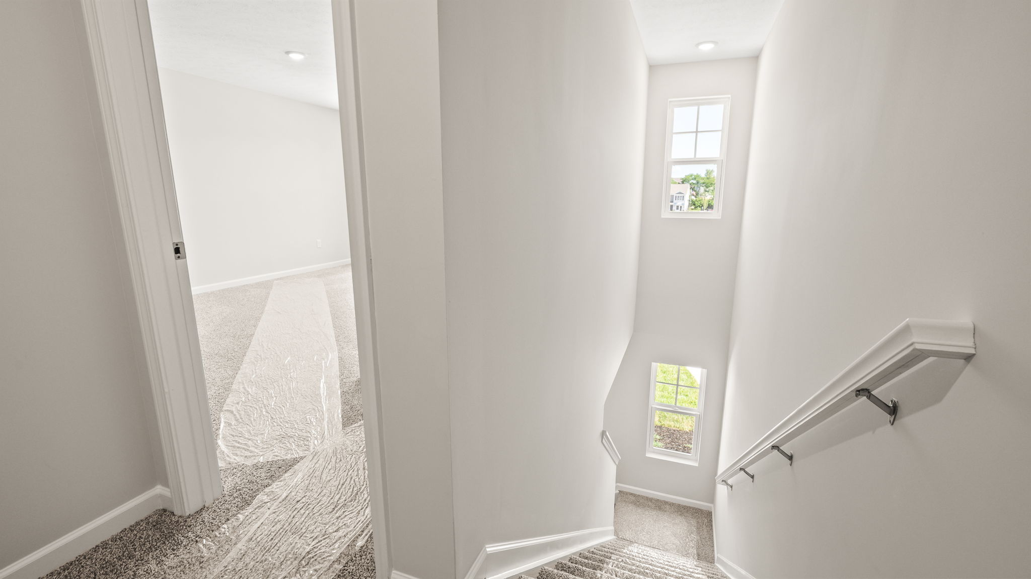 Upstairs landing with door to bedroom on the left, downstairs on the right