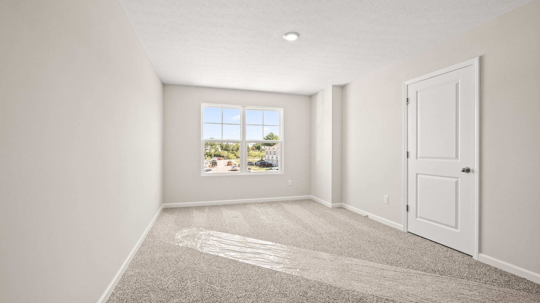 Primary bedroom with window and closet door