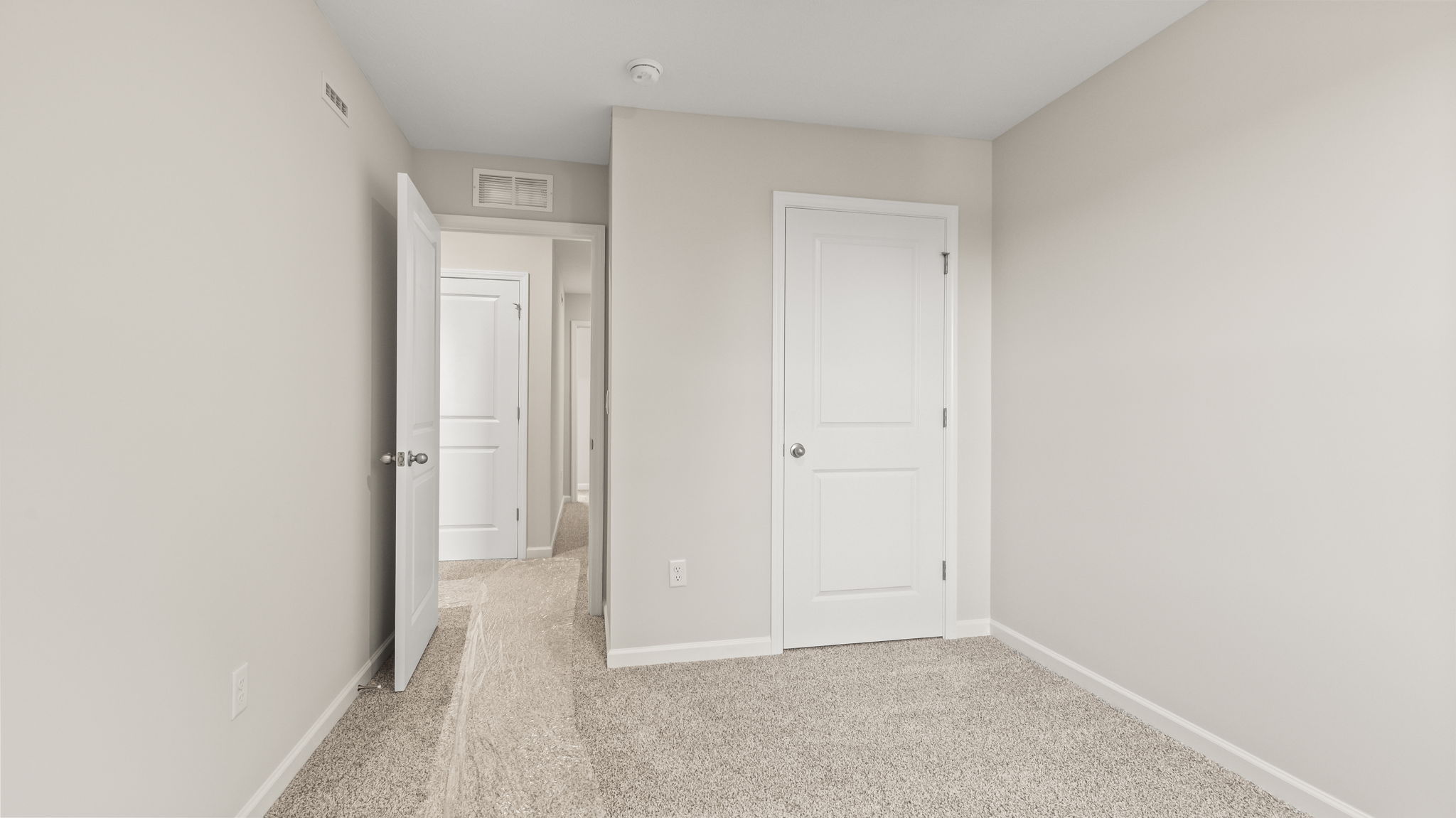 Carpeted bedroom with door to hallway