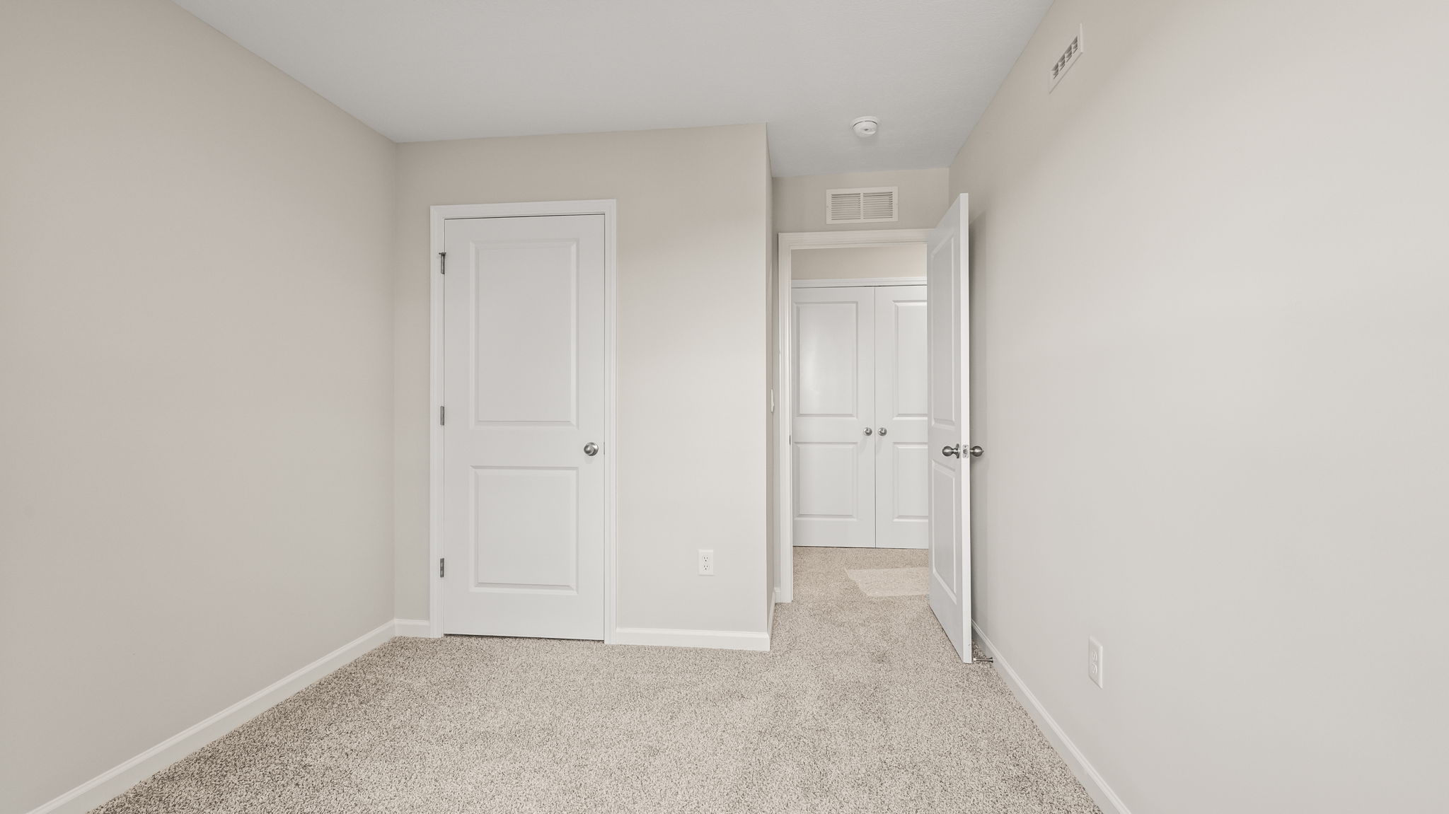 Carpeted bedroom with door to hallway