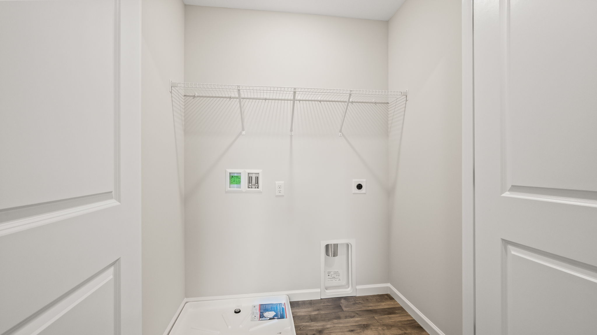 Laundry area with washer/dryer inlets and wire rack shelving