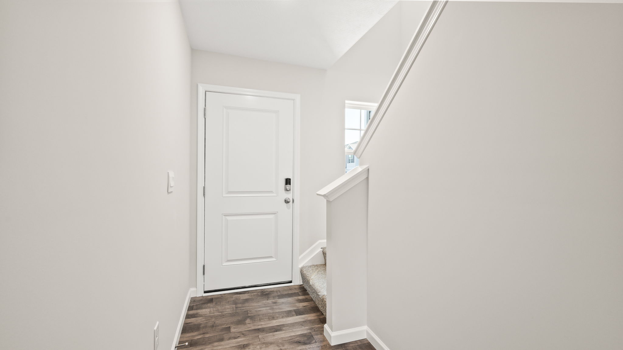 Foyer of townhome leading to front door and stairs to second floor