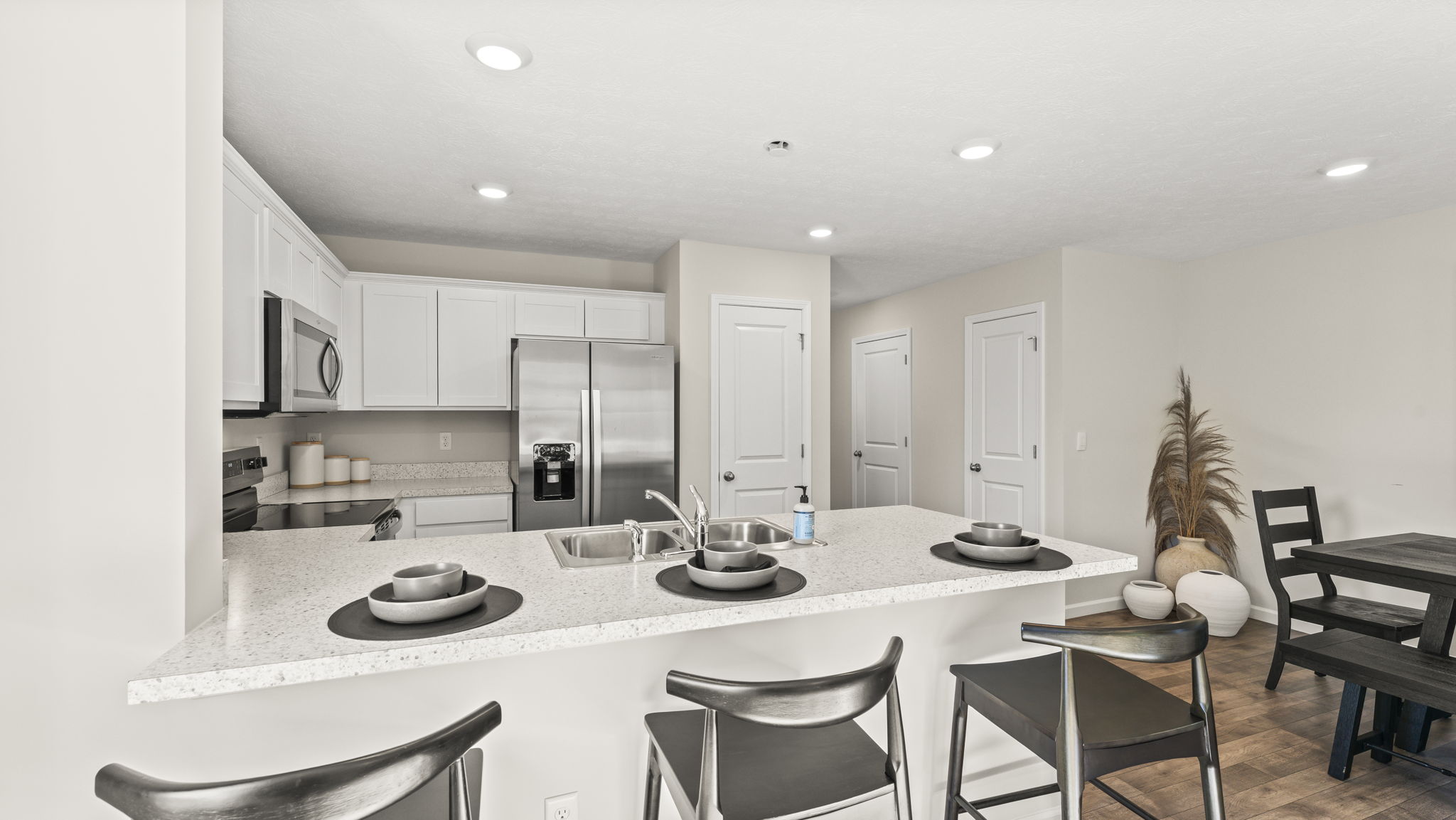 Full view of the kitchen with Whirlpool stainless steel appliances and white cabinets.