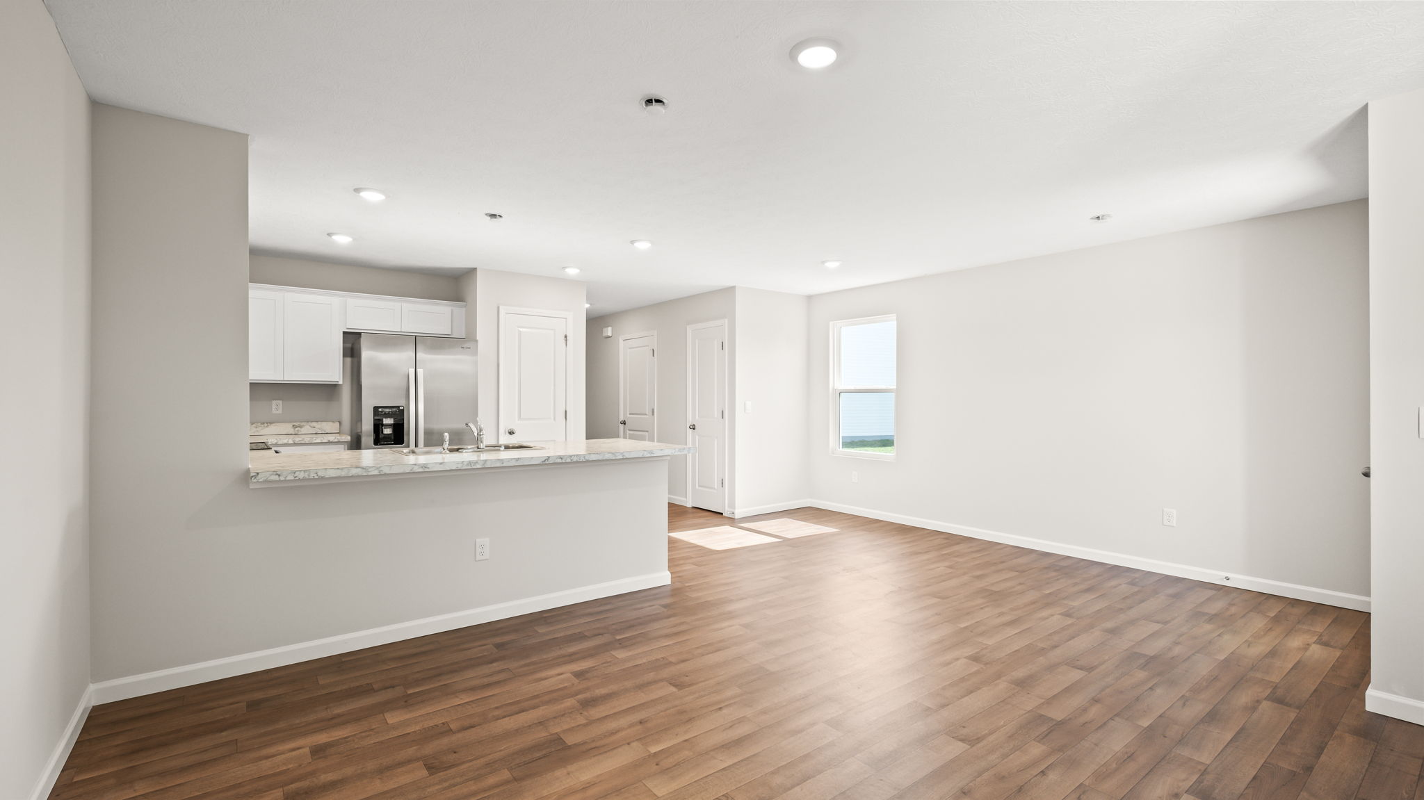 Wide image of living room with window to backyard on the right