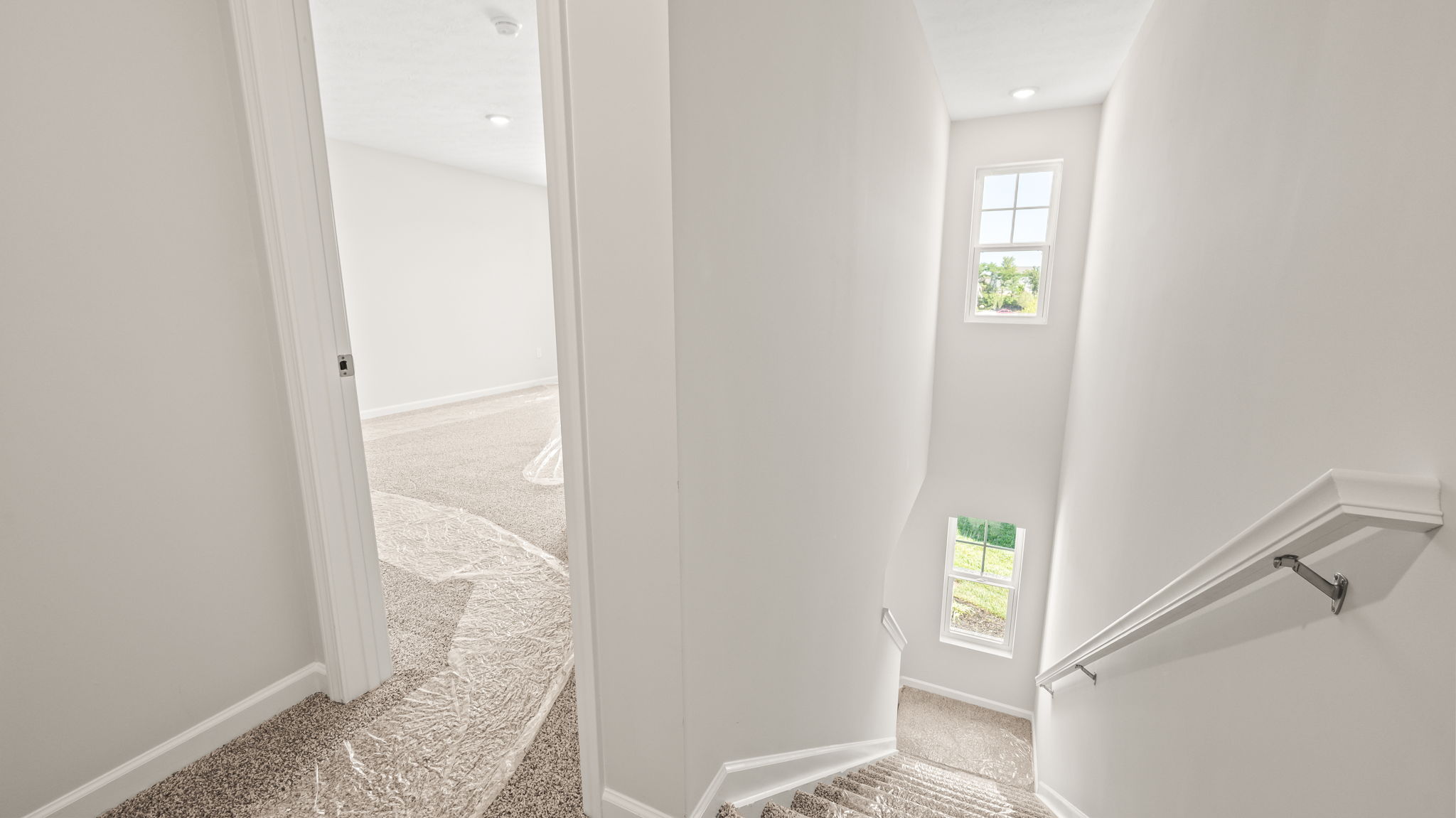 Upstairs landing with door to bedroom on the left, downstairs on the right